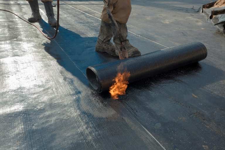 Licensed waterproofing professional inspecting completed membrane work with compliance and warranty indicators